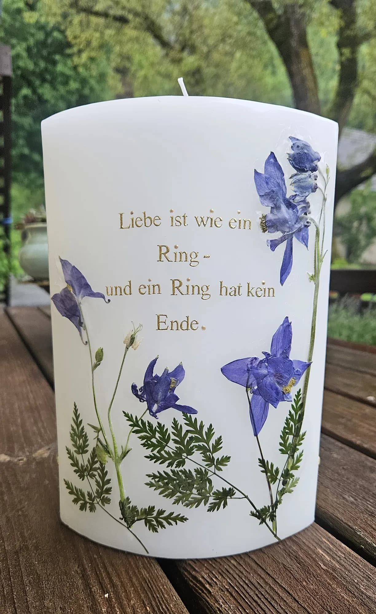 Hochzeitskerze mit blauen gepressten Blüten und goldenem Spruch